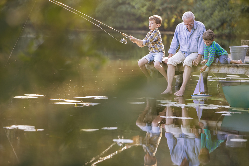 Grandpa and grandkids fishing in lake